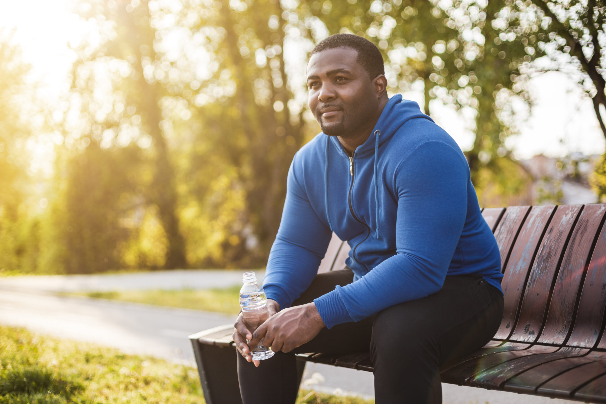 man resting on bench with a thoughtful look.